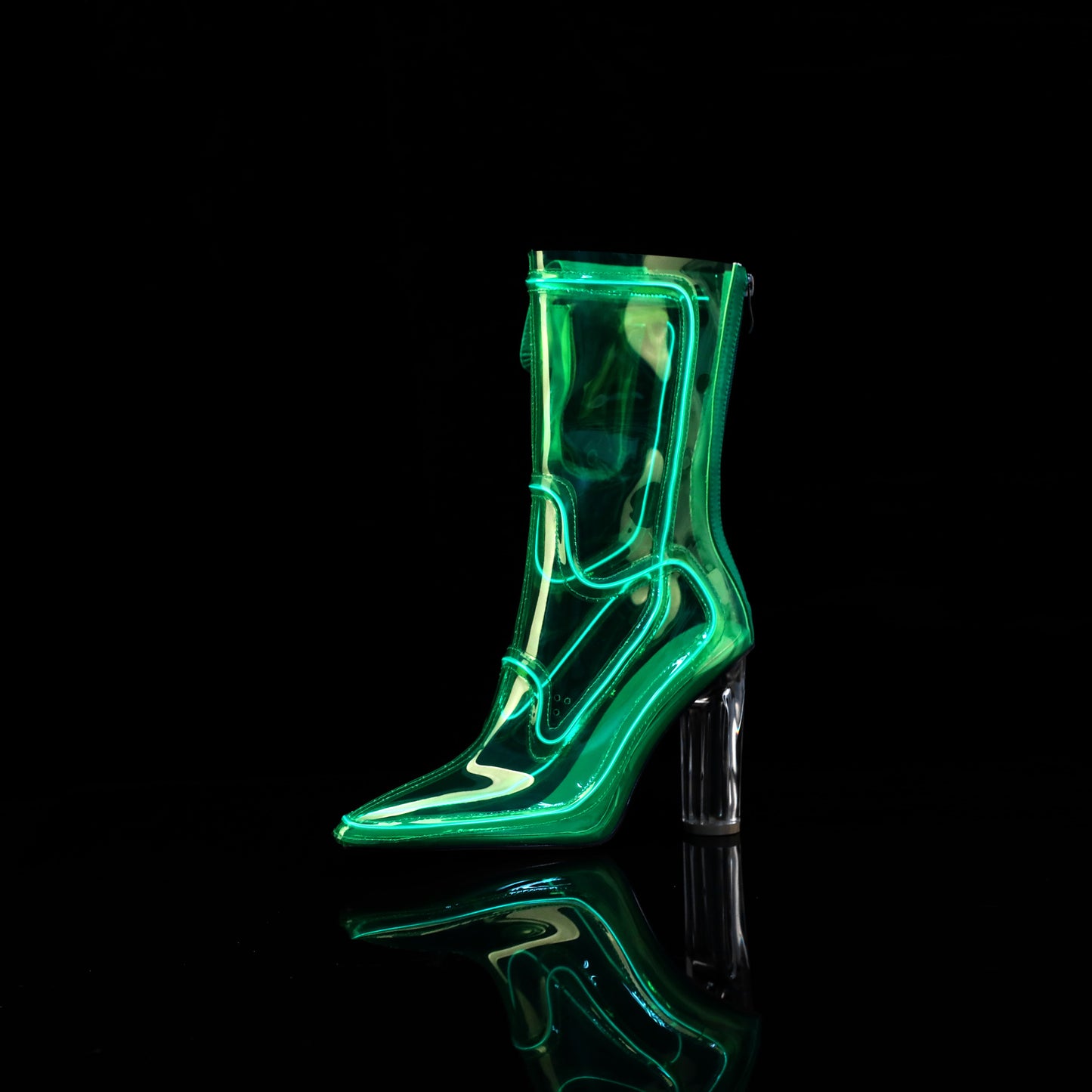 A single transparent high-heeled Cowboy LED boots with a bright neon green illuminated outline, shown on a glossy black reflective surface against a black background.